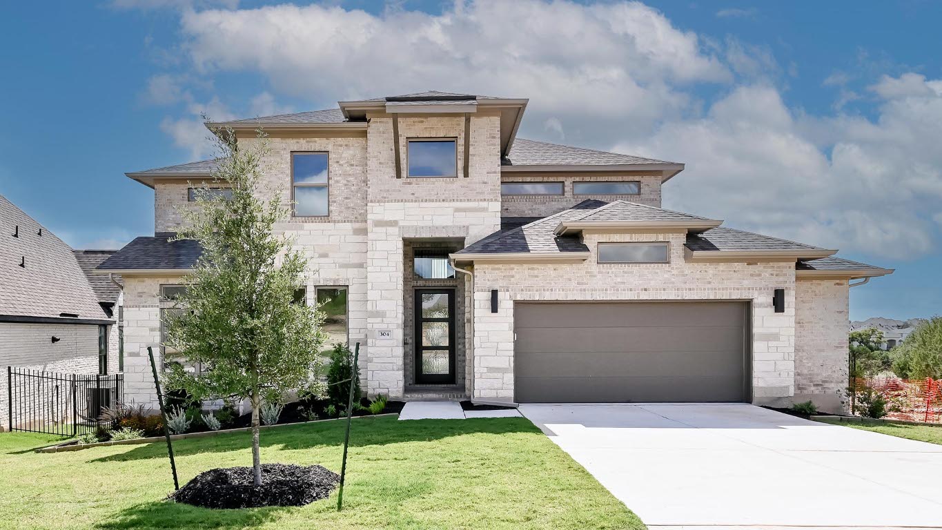 304 Leaning Rock Ridge Austin, TX 78737 - Photo 1 of 1 French country style house with driveway, an attached garage, a shingled roof, brick siding, and stone siding