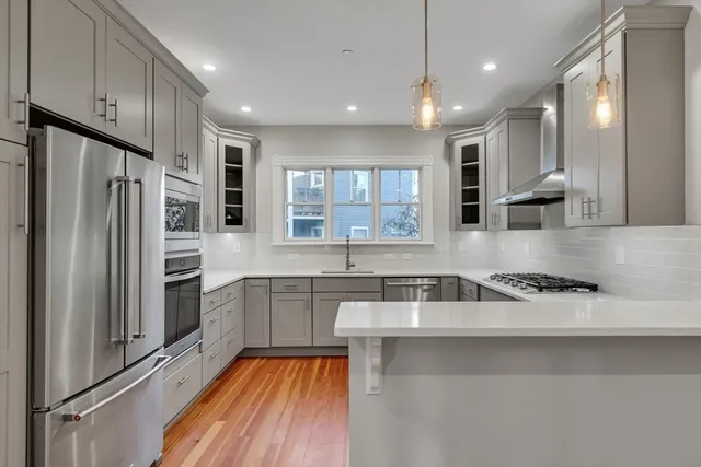 a kitchen with a sink a refrigerator and cabinets