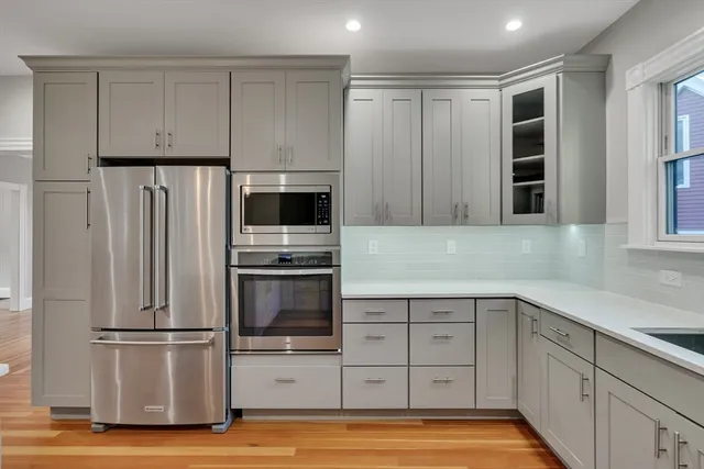 a kitchen with stainless steel appliances white cabinets and a refrigerator