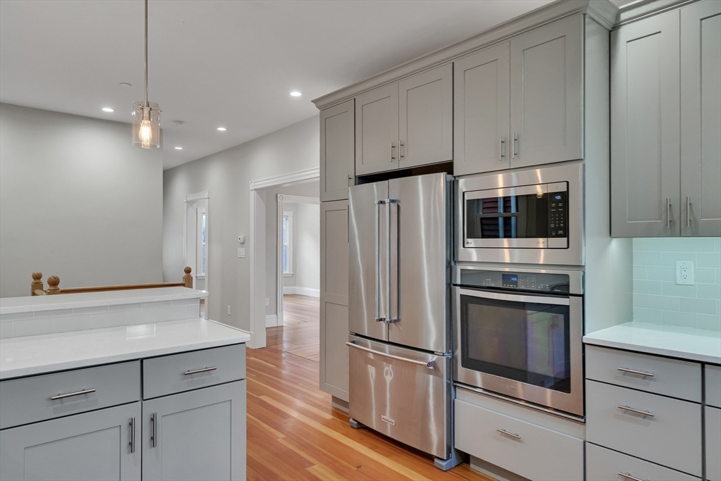16 Traymore Street, Unit 16 Cambridge, MA 02140 - Photo 5 of 22 a kitchen with stainless steel appliances white cabinets and wooden floor