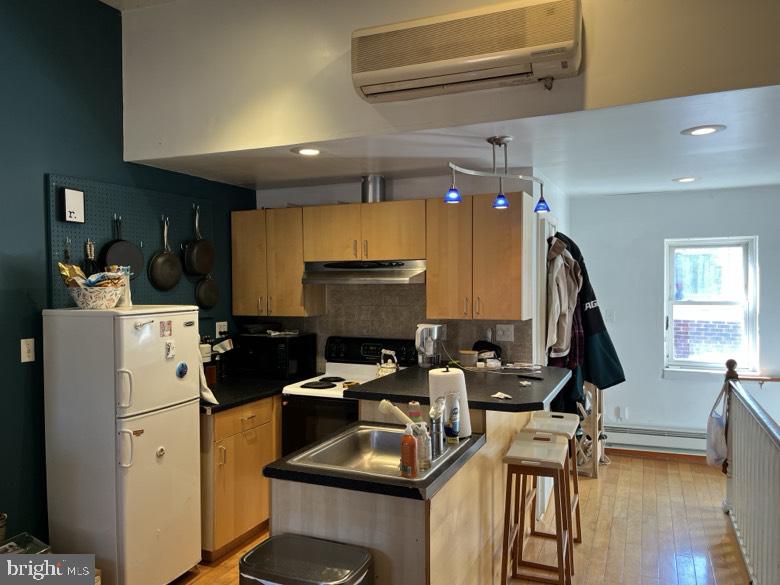 1202 South Street Philadelphia, PA 19147 - Photo 2 of 7 a kitchen with sink a refrigerator and a stove top oven