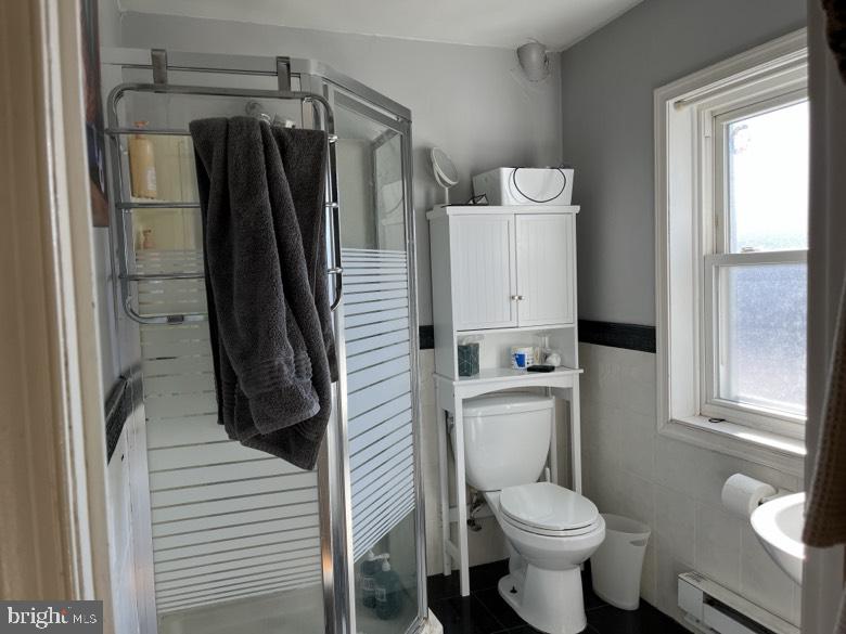 1202 South Street Philadelphia, PA 19147 - Photo 7 of 7 a white toilet sitting next to a bathroom sink and a shower