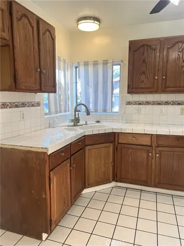 a kitchen with a sink a stove cabinets and wooden floor