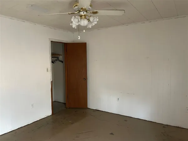 an empty room with a ceiling fan and a bathroom