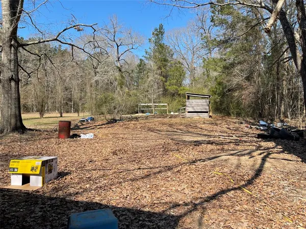 a view of a yard with wooden fence