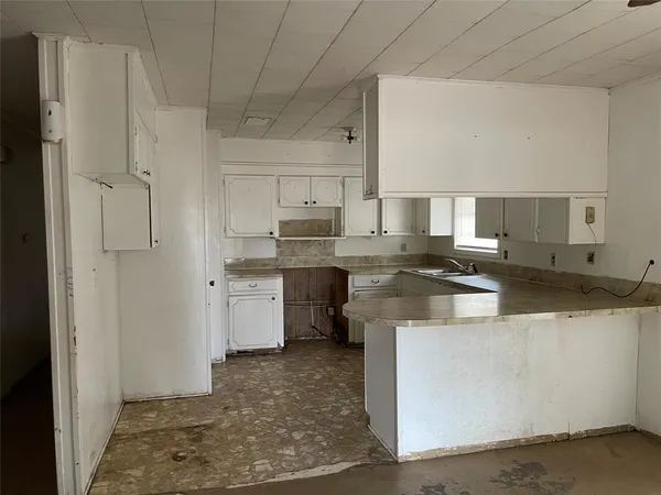 a kitchen with stainless steel appliances granite countertop a sink a stove a refrigerator and white cabinets