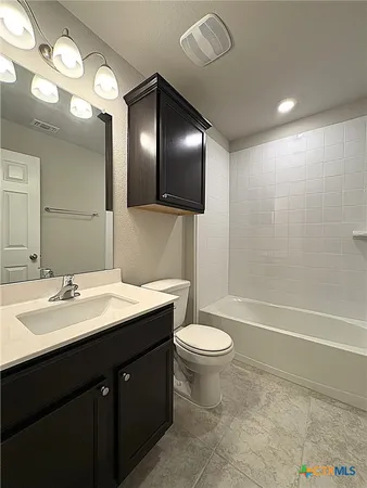 a bathroom with a sink a toilet and a large mirror