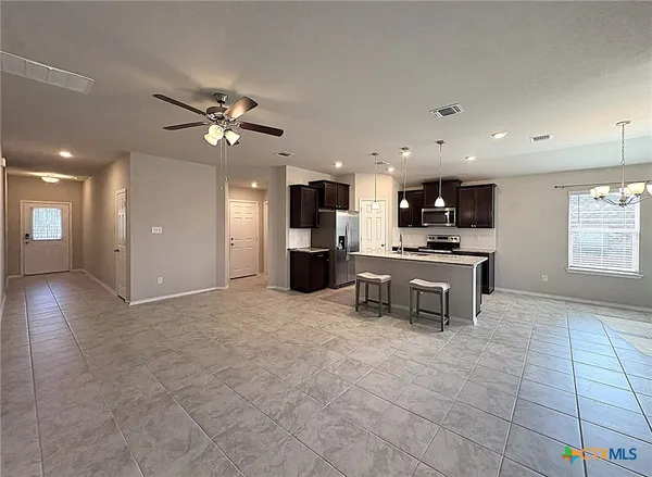 a view of kitchen with cabinets and refrigerator