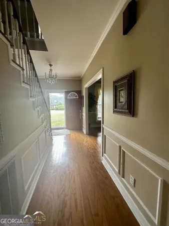 a view of hallway with stairs and wooden floor