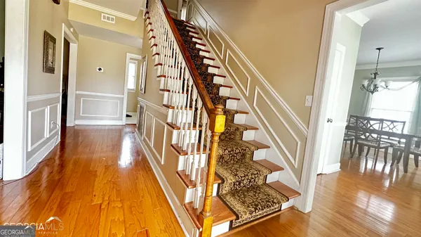 a view of a hallway with wooden floor and staircase