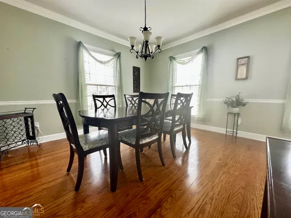 a view of a a dining room with furniture window and wooden floor