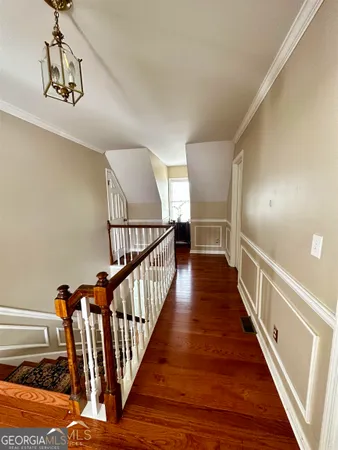 a view of a hallway with wooden floor and staircase