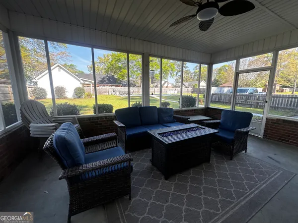 a living room with furniture and a floor to ceiling window