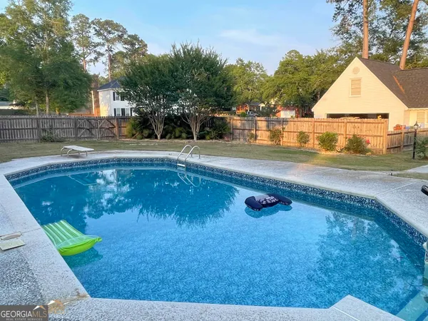 a view of backyard with table and chairs