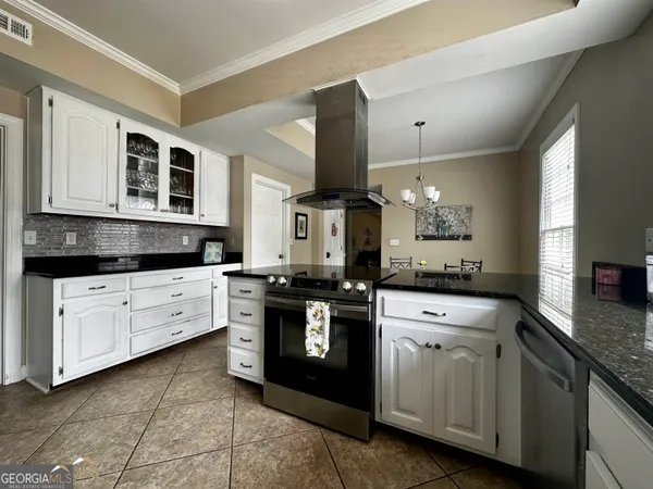 a kitchen with stainless steel appliances granite countertop a stove a sink and a microwave