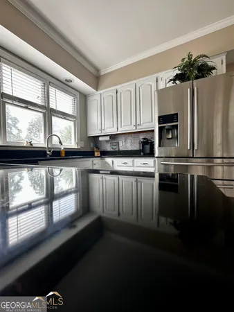 a kitchen with stainless steel appliances a microwave a sink and cabinets