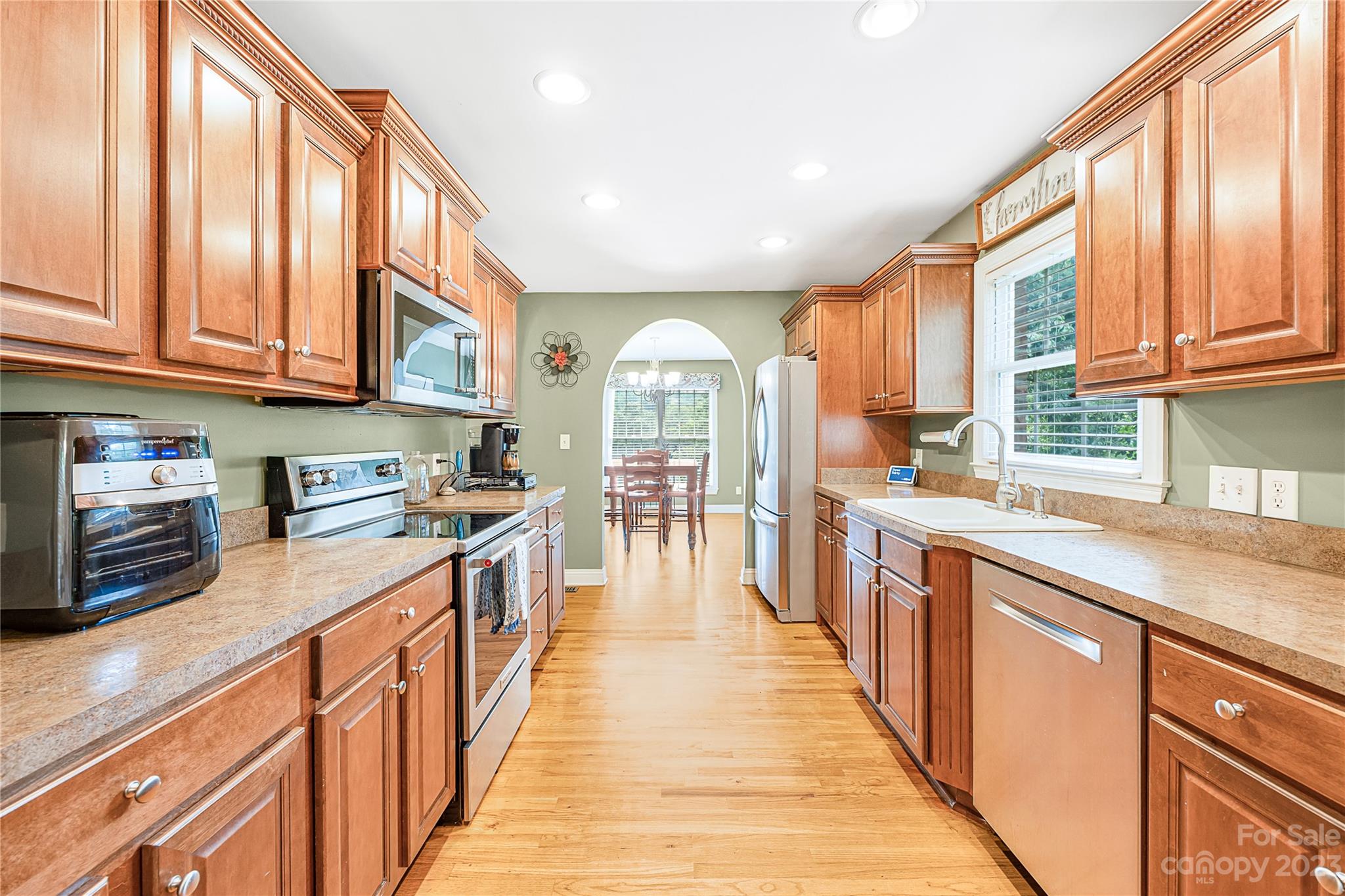 1463 Brookstone Drive Hickory, NC 28602 - Photo 6 of 40 a kitchen with stainless steel appliances granite countertop a stove a sink dishwasher and a refrigerator with wooden cabinets