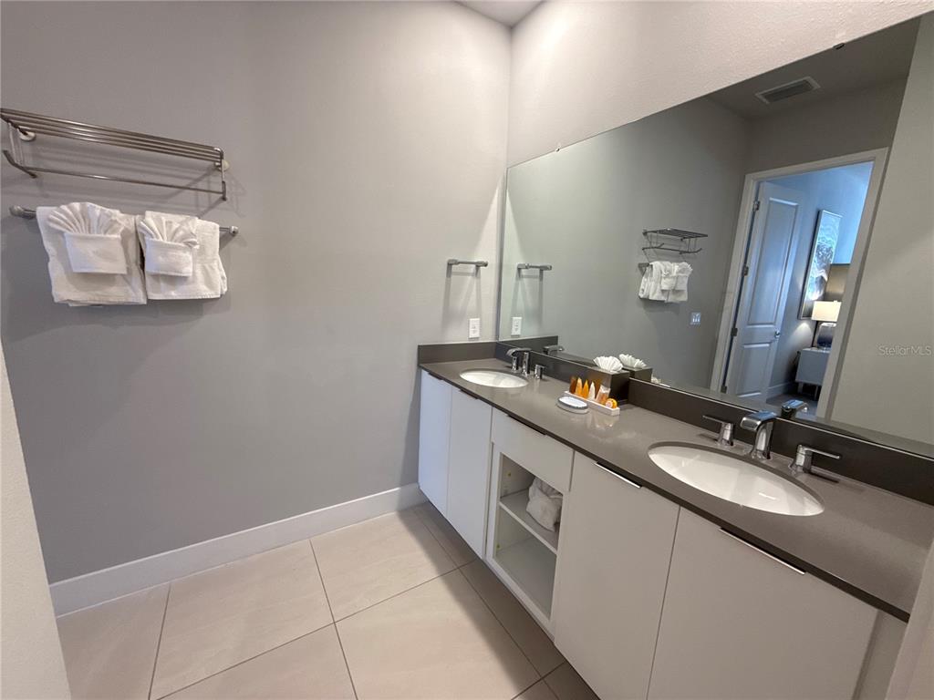 7740 Sandy Ridge Drive, Unit 120 Reunion, FL 34747 - Photo 20 of 36 a spacious bathroom with a double vanity sink and a mirror