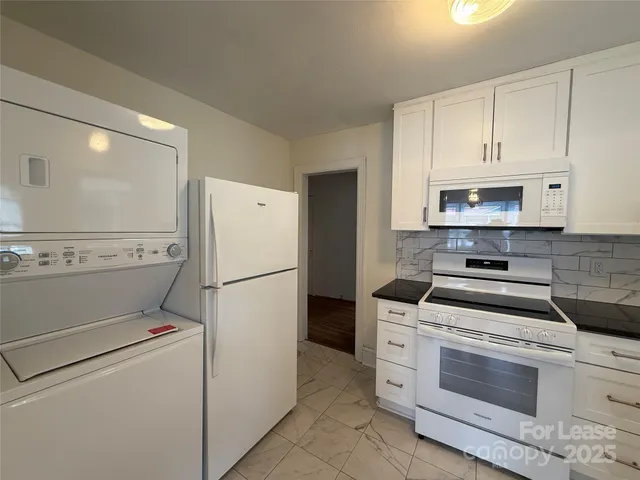 a kitchen with white cabinets and white appliances