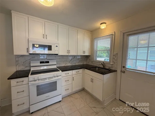 a kitchen with white cabinets and white appliances
