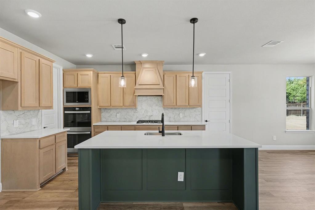 7041 Champion Road Midlothian, TX 76065 - Photo 9 of 30 a kitchen with kitchen island a sink stainless steel appliances and cabinets