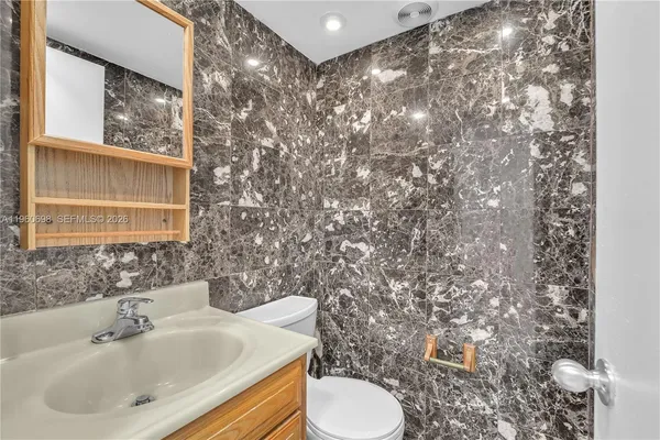 a bathroom with a toilet sink and mirror