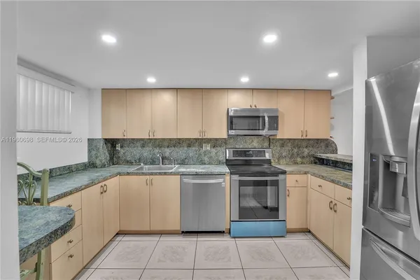 a kitchen with stainless steel appliances granite countertop a sink and stove top oven