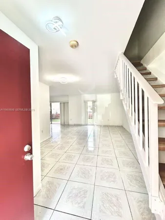 a view of a hallway with wooden floor and a rug