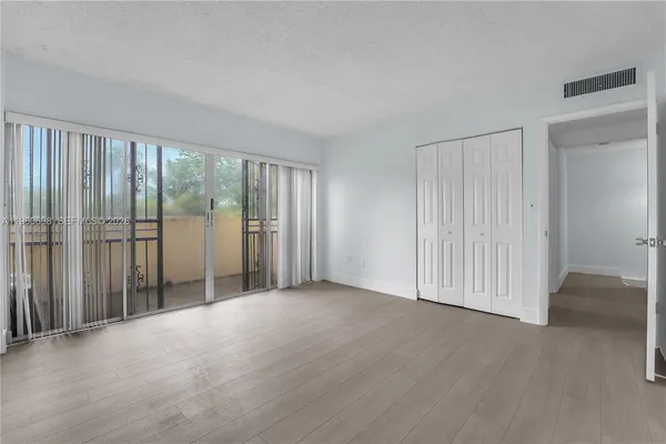 an empty room with sliding door and wooden floor