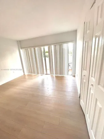 a view of a room with wooden floor and a window