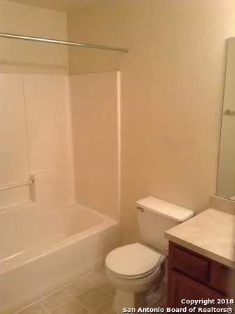 a white toilet sitting next to a bath tub and shower