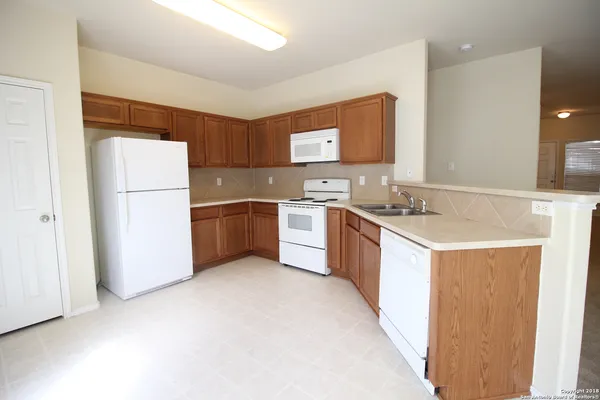 a kitchen with a sink a refrigerator a stove top oven a sink and dishwasher