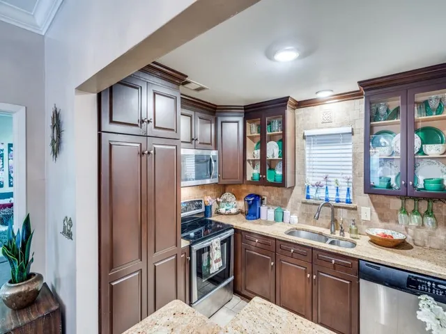a kitchen with stainless steel appliances granite countertop a refrigerator and a sink