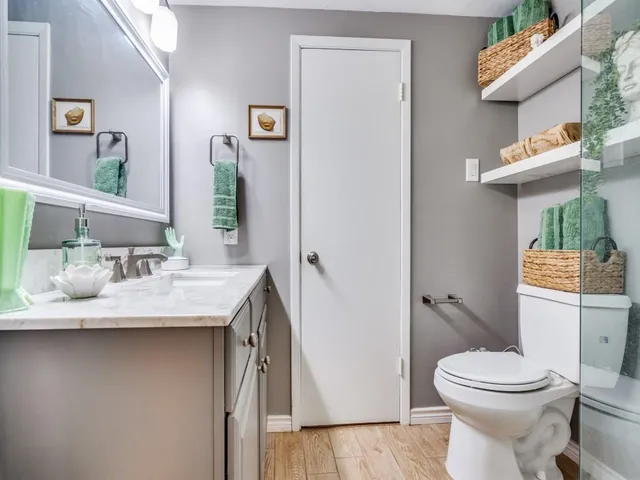 a bathroom with a granite countertop sink a toilet and shower