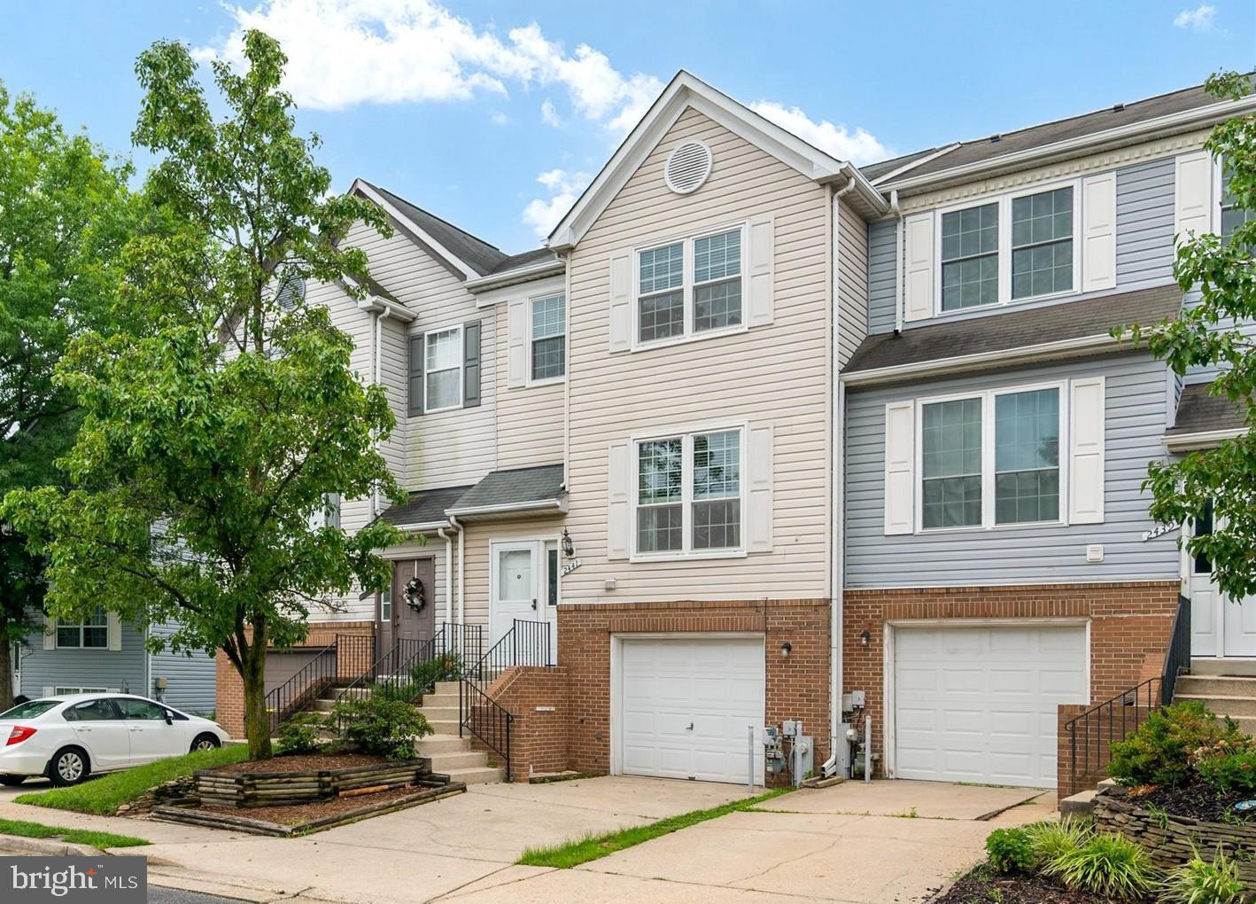 a front view of a house with yard and parking