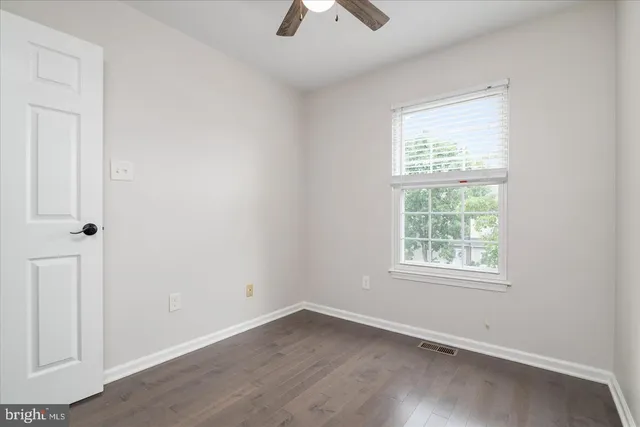 an empty room with a window and a ceiling fan