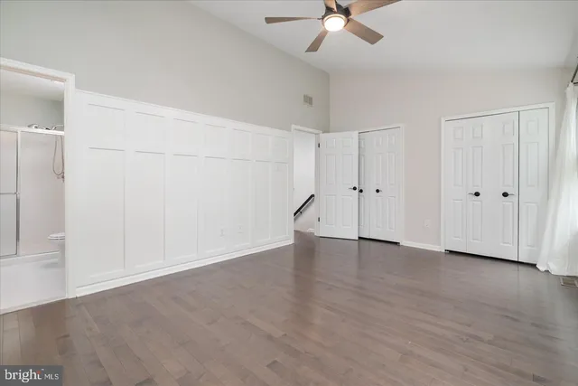 an empty room with an entryway and chandelier fan