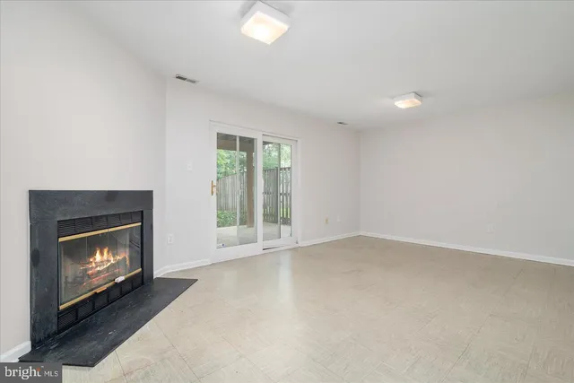 a view of an empty room with a fireplace and a window