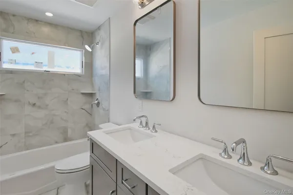 a bathroom with a double vanity sink mirror and shower