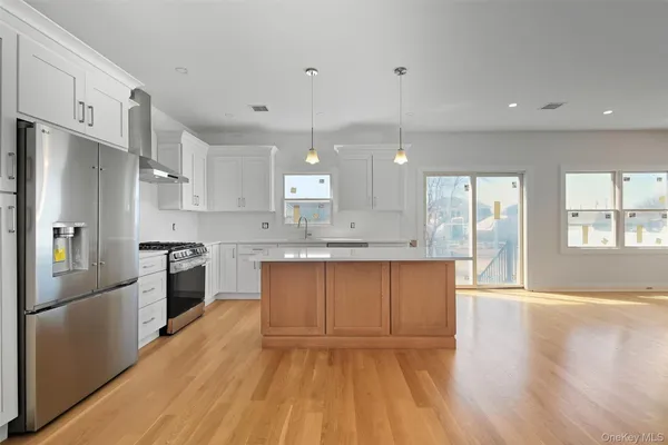 a large kitchen with granite countertop a large counter top stainless steel appliances and cabinets