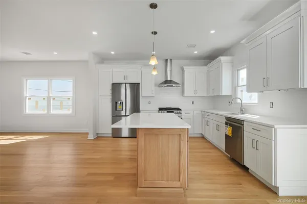 a large kitchen with stainless steel appliances kitchen island a large counter top and a sink