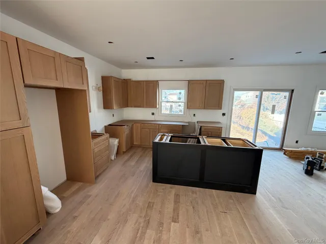 a living room with stainless steel appliances kitchen island granite countertop a refrigerator a sink a stove a dining table and chairs