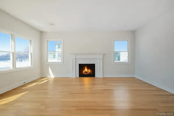 a view of an empty room with window and fire place