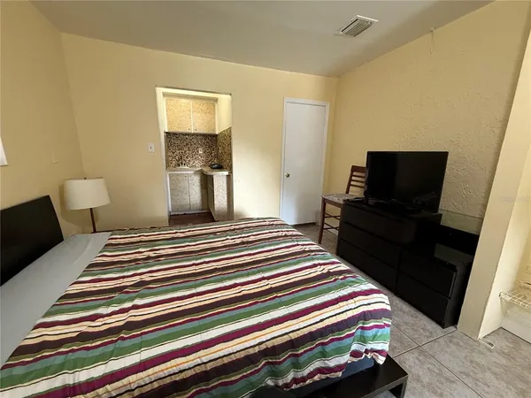 a bedroom with a bed and a flat screen tv
