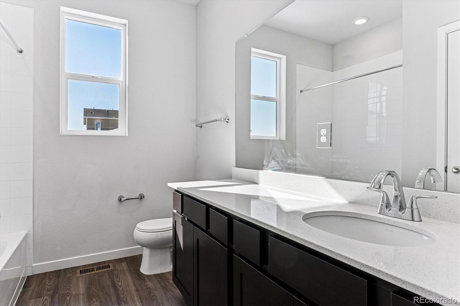 4224 Gozzer Ranch Drive Elizabeth, CO 80107 - Photo 9 of 21 a bathroom with a granite countertop sink a toilet and a mirror