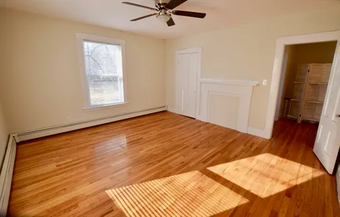 a view of a room with wooden floor and white walls