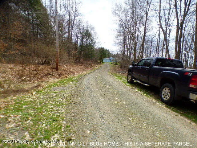 a view of a yard with a car parked in front of it
