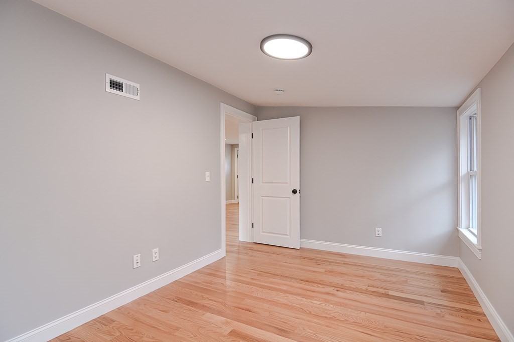 108 Olive Street Ashland, MA 01721 - Photo 25 of 34 a view of an empty room with wooden floor and windows