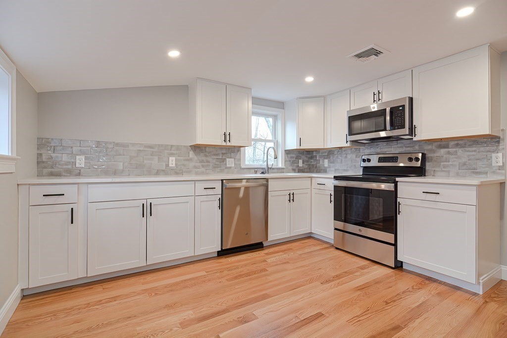 108 Olive Street Ashland, MA 01721 - Photo 3 of 34 a kitchen with stainless steel appliances granite countertop a stove top oven a sink dishwasher and a refrigerator