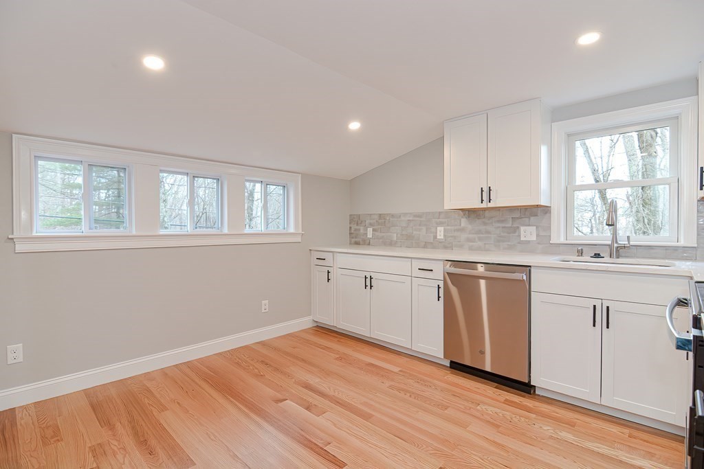 108 Olive Street Ashland, MA 01721 - Photo 4 of 34 a kitchen with granite countertop white cabinets and white appliances with wooden floor